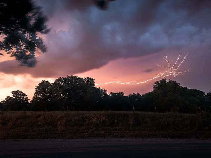a lightning bolt is seen in the sky over a field